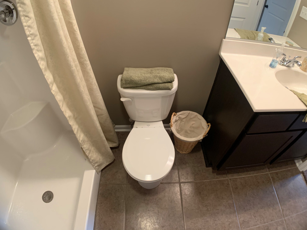 Classic bathroom in Chicago with flat-panel cabinets, dark wood cabinets, a walk-in shower, a one-piece toilet, beige walls, ceramic flooring, engineered stone worktops, multi-coloured floors, a shower curtain, white worktops and an integrated sink.