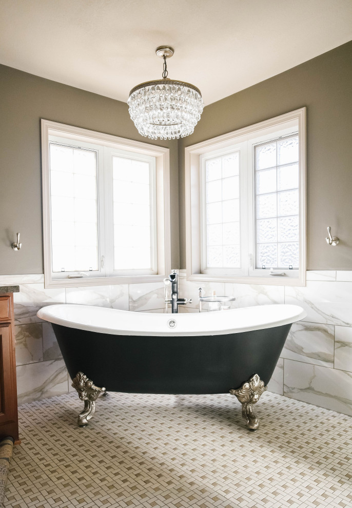 Bathroom - large traditional master beige tile and marble tile porcelain tile and multicolored floor bathroom idea in Omaha with raised-panel cabinets, dark wood cabinets, brown walls, an undermount sink, quartz countertops, a hinged shower door and black countertops