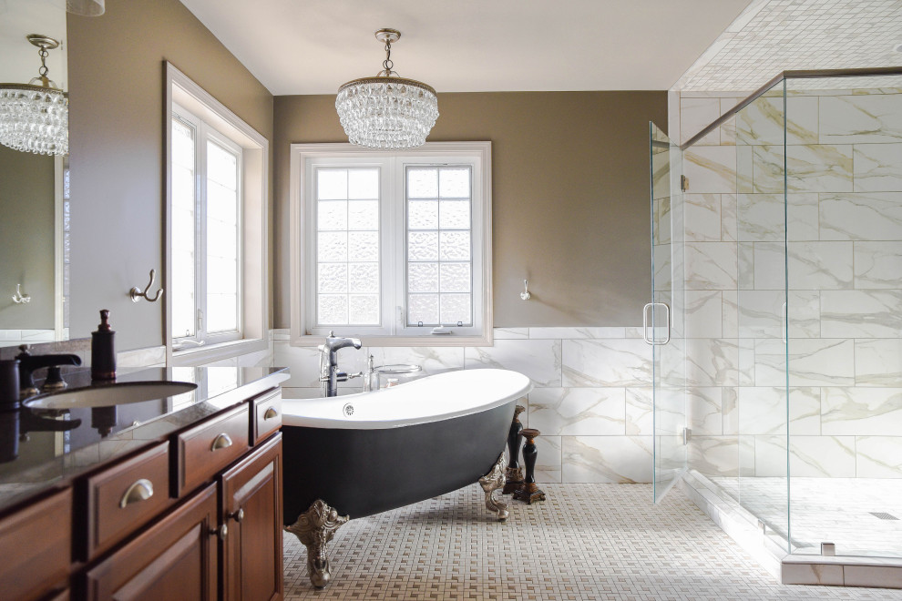 Large elegant master beige tile and marble tile porcelain tile and multicolored floor bathroom photo in Omaha with raised-panel cabinets, dark wood cabinets, brown walls, an undermount sink, quartz countertops, a hinged shower door and black countertops