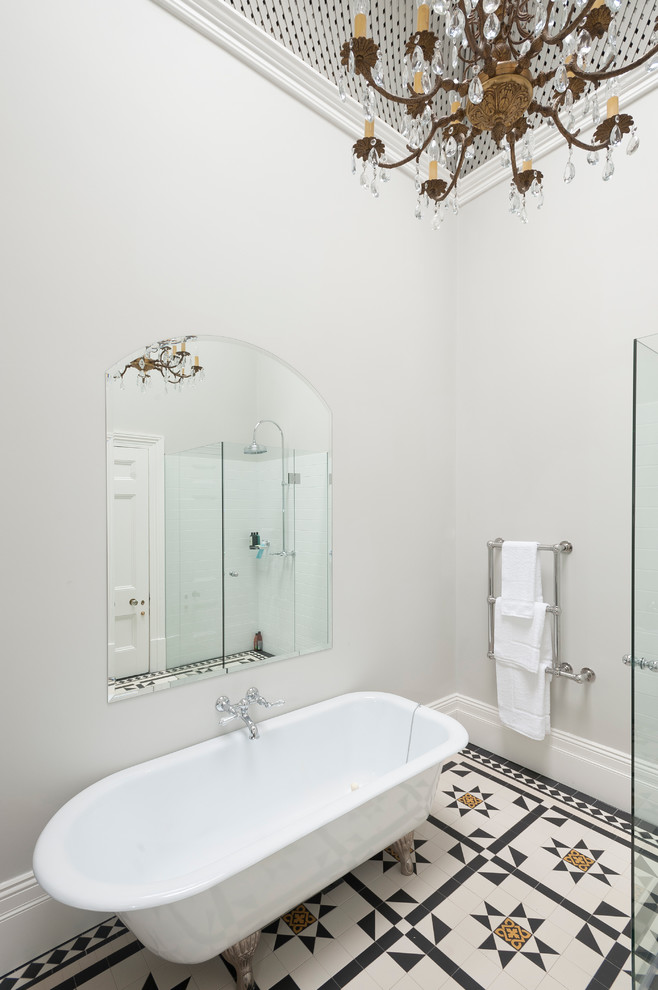 Cette image montre une salle d'eau traditionnelle de taille moyenne avec une baignoire sur pieds, une douche d'angle, un carrelage blanc, des carreaux de céramique, un mur blanc et un sol en carrelage de céramique.