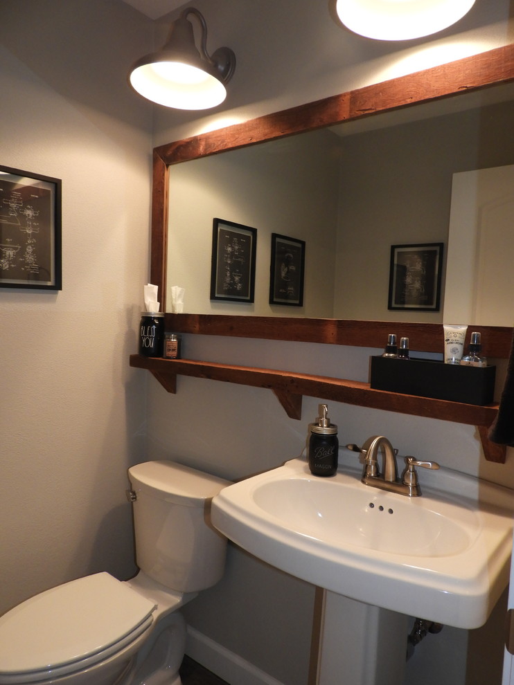 Foto di una stanza da bagno classica di medie dimensioni con WC a due pezzi, piastrelle beige, pareti beige, pavimento in legno massello medio, lavabo a colonna e pavimento grigio