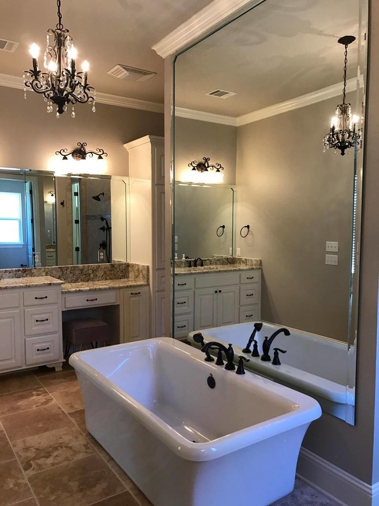 Klassisk inredning av ett stort en-suite badrum, med luckor med upphöjd panel, vita skåp, ett fristående badkar, en öppen dusch, brun kakel, porslinskakel, beige väggar, travertin golv, ett undermonterad handfat, granitbänkskiva, brunt golv och med dusch som är öppen
