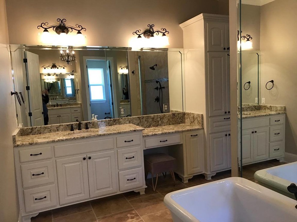 Example of a large classic master brown tile and porcelain tile travertine floor and brown floor bathroom design in New Orleans with raised-panel cabinets, white cabinets, beige walls, an undermount sink and granite countertops