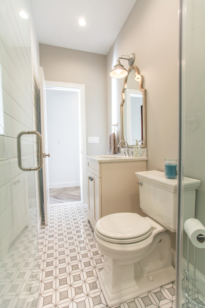 ニューヨークにある中くらいなビーチスタイルのおしゃれな浴室 (白いキャビネット、ダブルシャワー、グレーの壁、大理石の床、アンダーカウンター洗面器、大理石の洗面台、開き戸のシャワー) の写真