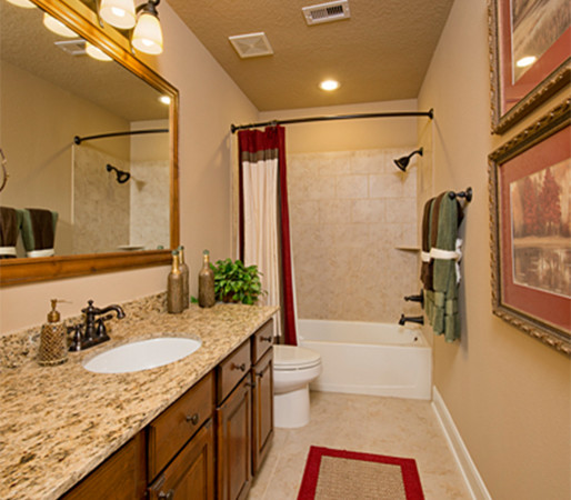 Design ideas for a medium sized traditional shower room bathroom in Houston with raised-panel cabinets, medium wood cabinets, an alcove bath, a shower/bath combination, a two-piece toilet, beige tiles, ceramic tiles, beige walls, ceramic flooring, a submerged sink, granite worktops, beige floors, a shower curtain and multi-coloured worktops.