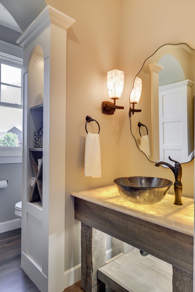 Aménagement d'une petite salle de bain classique en bois brun avec une vasque, un plan de toilette en onyx, WC à poser, un mur gris et parquet foncé.