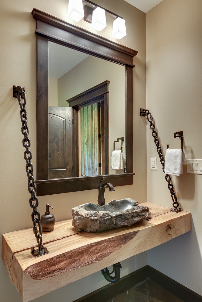 Example of a mid-sized transitional gray tile and stone tile slate floor bathroom design in Minneapolis with a vessel sink, recessed-panel cabinets, dark wood cabinets, wood countertops, a one-piece toilet and brown walls