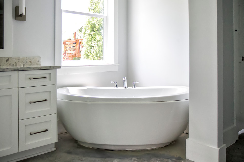 Design ideas for a medium sized modern ensuite bathroom in Jacksonville with shaker cabinets, white cabinets, a freestanding bath, white walls, concrete flooring, a submerged sink and concrete worktops.