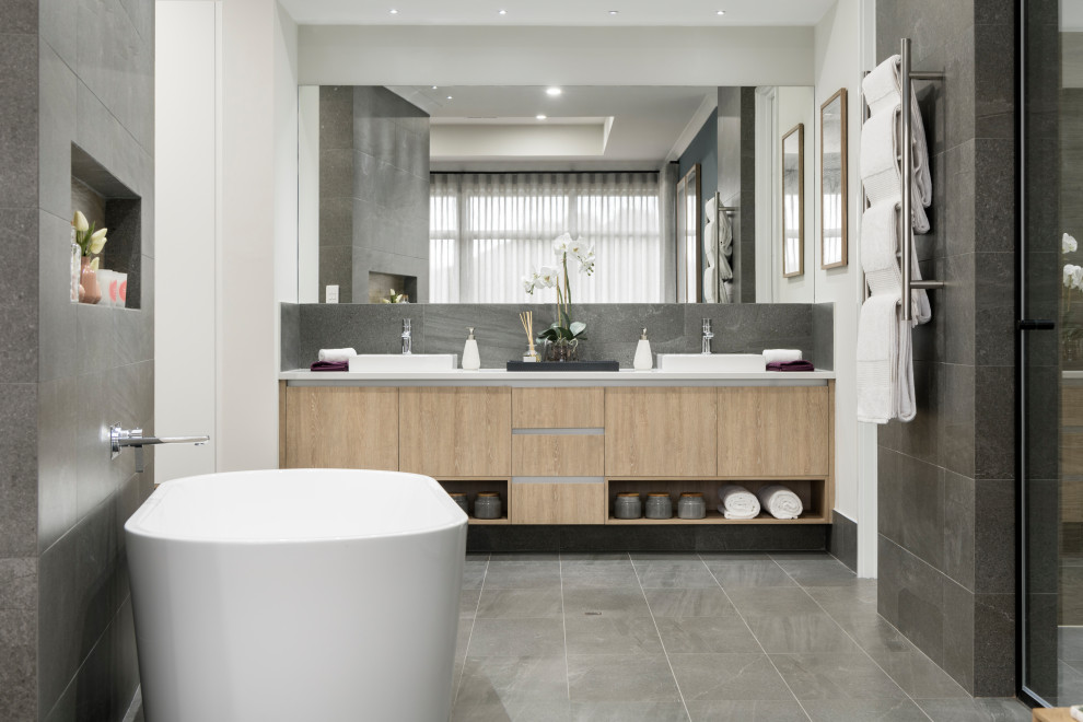 Inspiration for a medium sized contemporary ensuite bathroom in Perth with flat-panel cabinets, light wood cabinets, an alcove shower, grey tiles, porcelain tiles, white walls, a vessel sink, grey floors, a hinged door, white worktops, a wall niche, double sinks and a built in vanity unit.