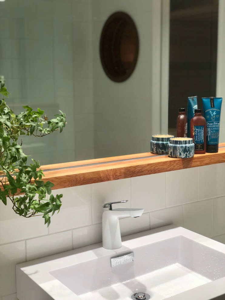 Photo of a medium sized scandinavian sauna bathroom in Charleston with flat-panel cabinets, white cabinets, an alcove bath, a shower/bath combination, a one-piece toilet, white tiles, ceramic tiles, white walls, ceramic flooring, an integrated sink, engineered stone worktops, beige floors, white worktops, a single sink and a floating vanity unit.