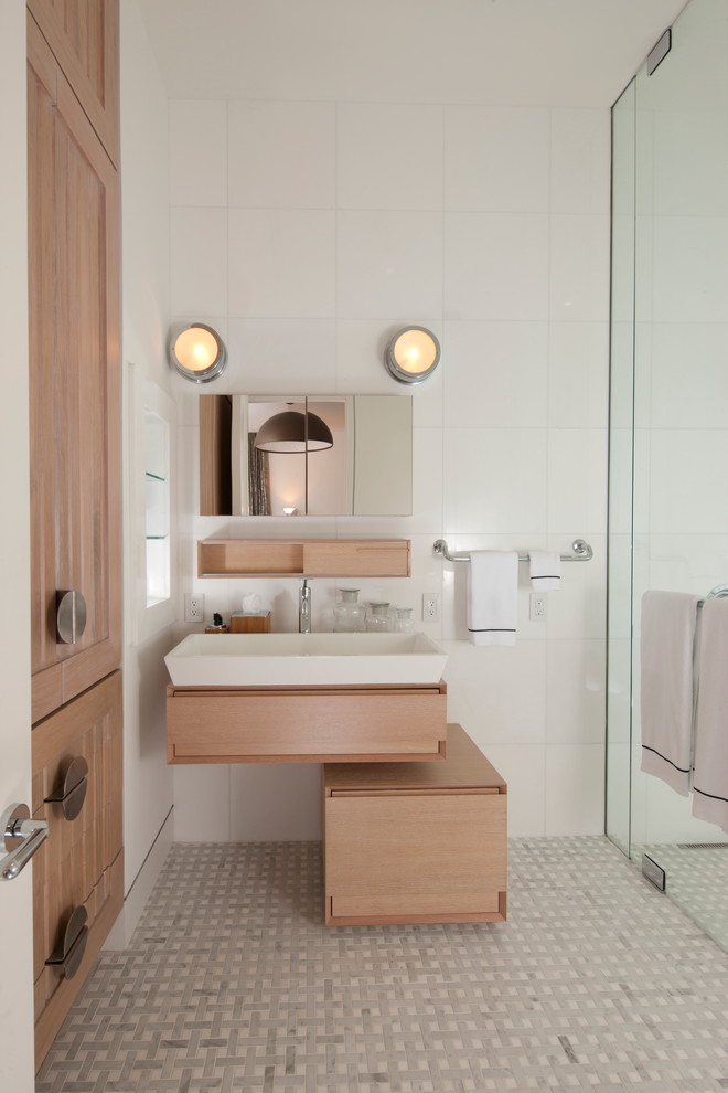 Источник вдохновения для домашнего уюта: ванная комната в современном стиле с подвесной раковиной, светлыми деревянными фасадами, душем в нише и белой плиткой