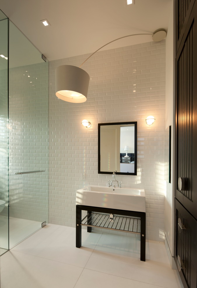オースティンにあるコンテンポラリースタイルのおしゃれな浴室 (コンソール型シンク、白いタイル、サブウェイタイル) の写真