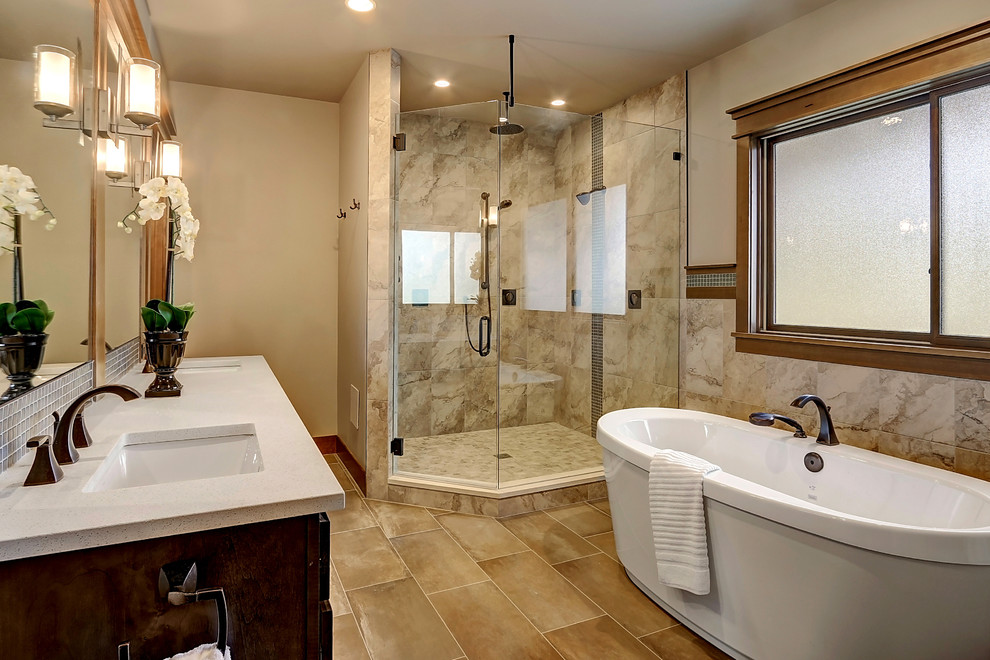 Idée de décoration pour une grande salle de bain principale craftsman en bois foncé avec une baignoire indépendante, une douche d'angle, un carrelage beige, un carrelage de pierre, un mur blanc, un sol en carrelage de porcelaine, un lavabo encastré et un plan de toilette en quartz modifié.