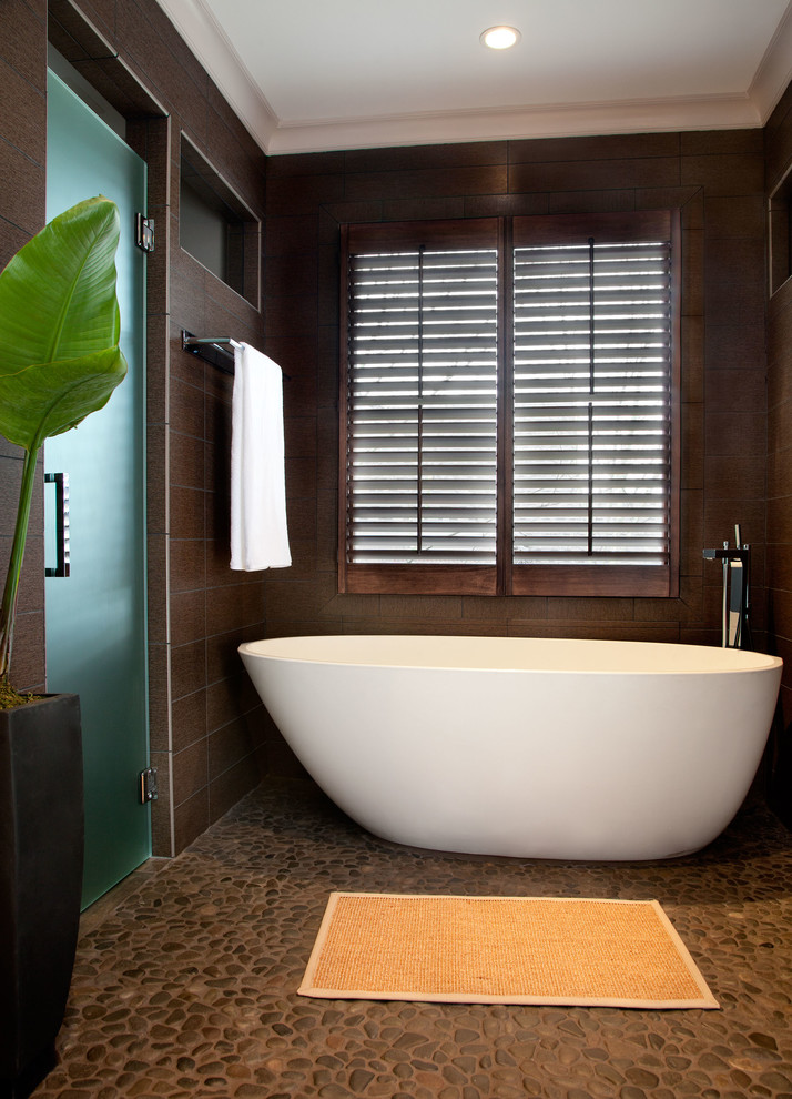 Immagine di una stanza da bagno tradizionale con vasca freestanding, piastrelle marroni, doccia a filo pavimento e pavimento con piastrelle di ciottoli