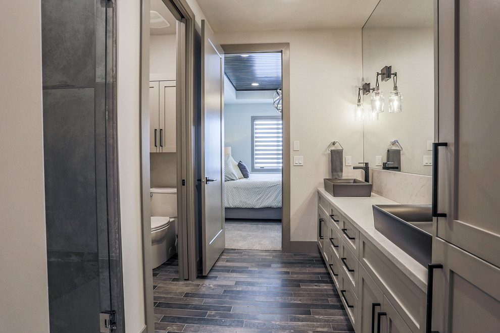 Example of a minimalist master porcelain tile bathroom design in Omaha with shaker cabinets, a vessel sink, quartz countertops, a hinged shower door and a two-piece toilet