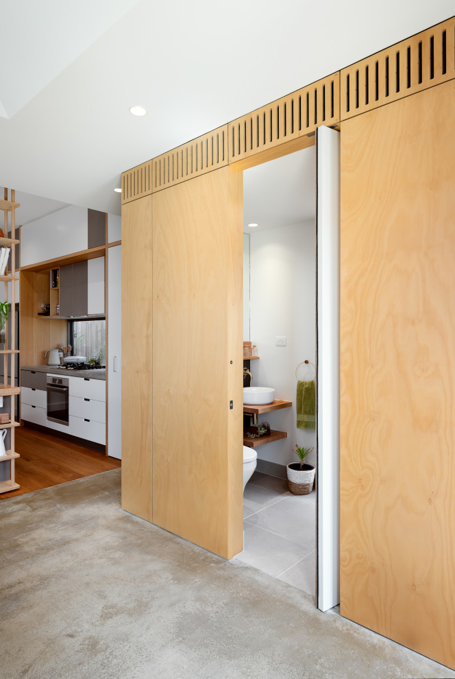 Kleine Moderne Gästetoilette mit Waschtisch aus Holz, freistehendem Waschtisch, Holzwänden und Keramikboden in Melbourne