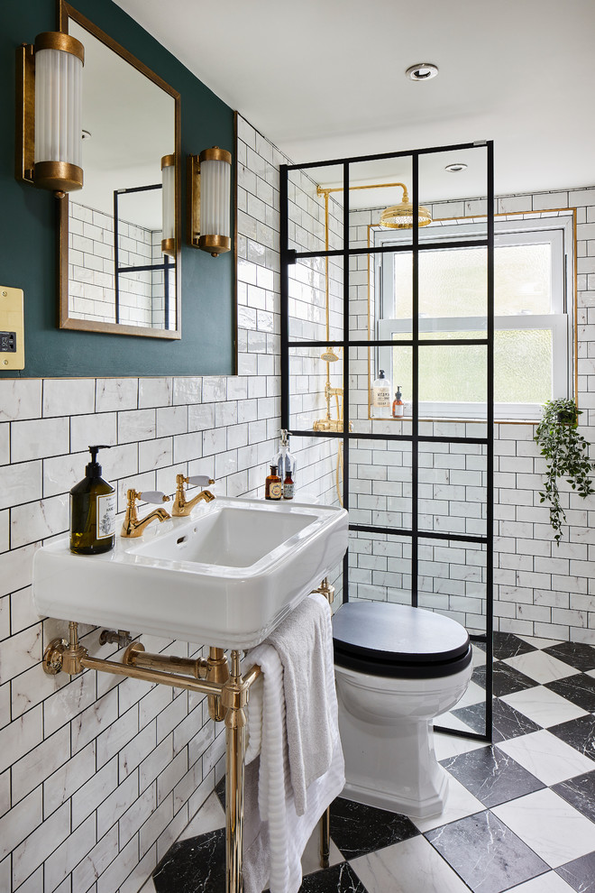 Klassisk inredning av ett badrum med dusch, med vit kakel, tunnelbanekakel, gröna väggar, ett konsol handfat, flerfärgat golv och med dusch som är öppen