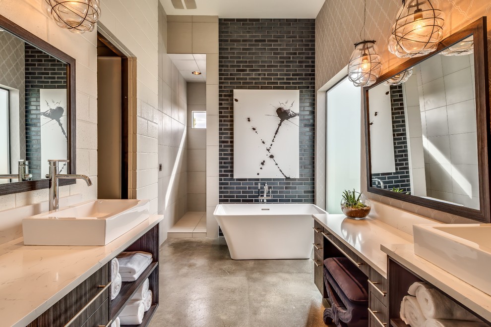 Стильный дизайн: главная ванная комната в стиле лофт с настольной раковиной, темными деревянными фасадами, отдельно стоящей ванной, черной плиткой, плиткой кабанчик и бетонным полом - последний тренд