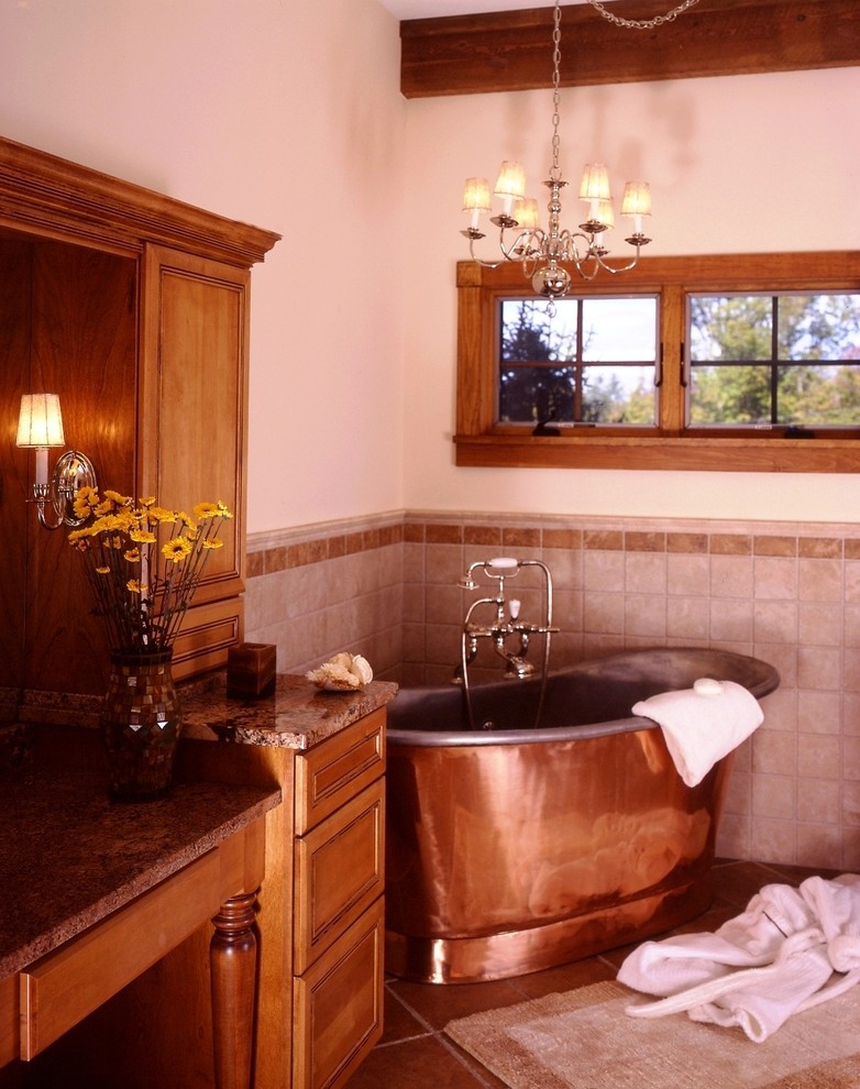マンチェスターにある広いトラディショナルスタイルのおしゃれなマスターバスルーム (インセット扉のキャビネット、中間色木目調キャビネット、置き型浴槽、ベージュのタイル、茶色いタイル、セラミックタイル、白い壁、セラミックタイルの床、御影石の洗面台) の写真