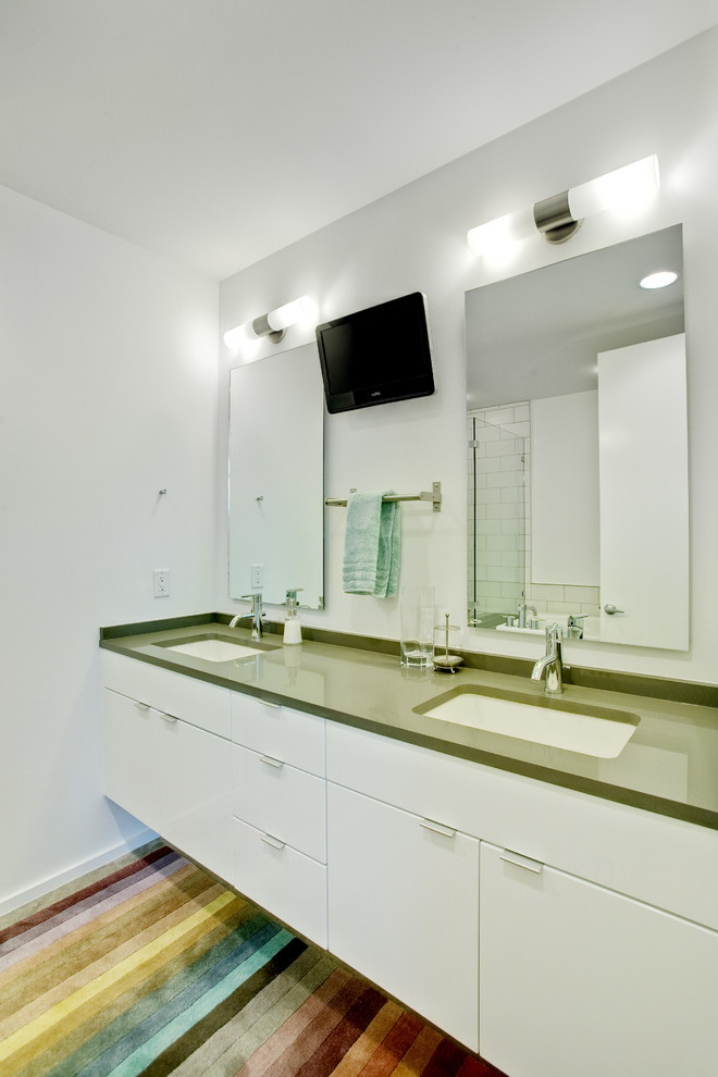 Modernes Badezimmer mit Unterbauwaschbecken, flächenbündigen Schrankfronten, weißen Schränken, Eckdusche, Metrofliesen und grüner Waschtischplatte in Austin