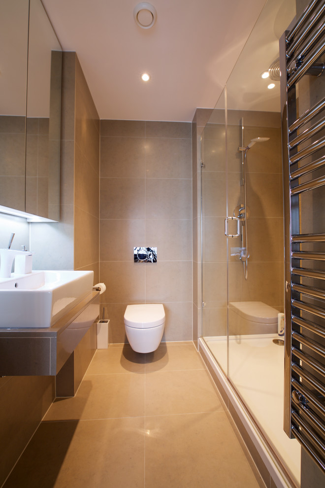 Réalisation d'une salle de bain design avec un plan vasque, un plan de toilette en calcaire, une douche double, WC suspendus, un carrelage beige, un mur beige et un sol en calcaire.