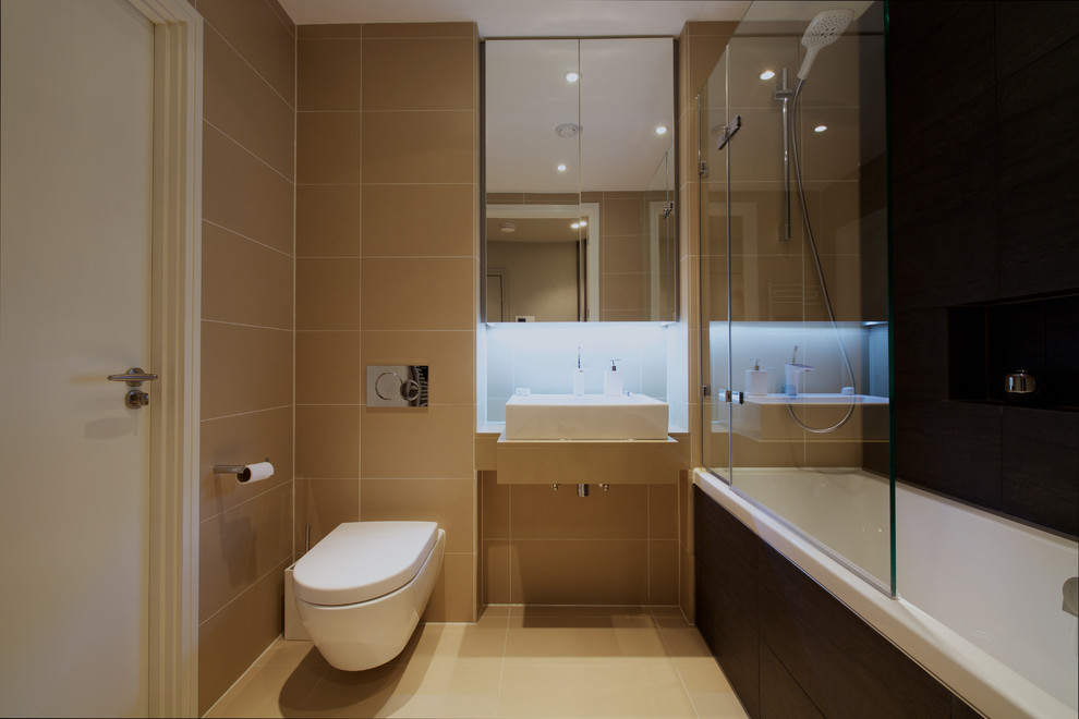 Идея дизайна: главная ванная комната: освещение в современном стиле с консольной раковиной, столешницей из известняка, ванной в нише, душем над ванной, инсталляцией и полом из известняка