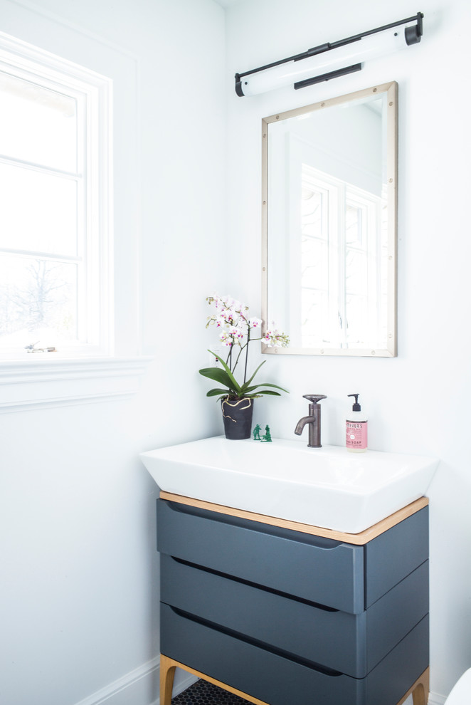 Kleines Klassisches Badezimmer mit grauen Schränken, grauer Wandfarbe, dunklem Holzboden, Aufsatzwaschbecken, braunem Boden und flächenbündigen Schrankfronten in New York