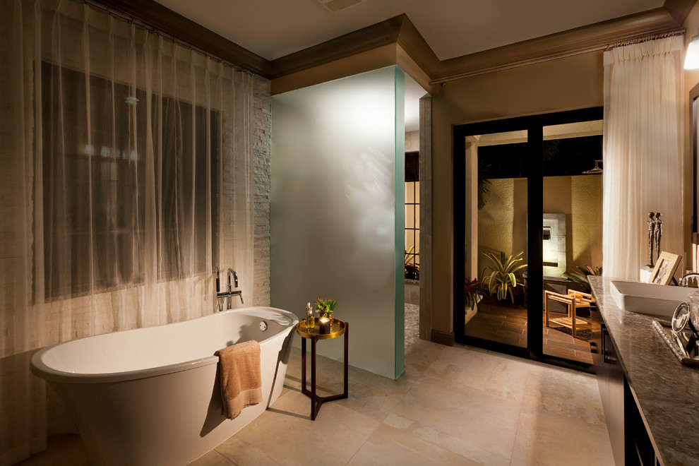 Medelhavsstil inredning av ett stort en-suite badrum, med skåp i mörkt trä, ett fristående badkar, beige väggar, klinkergolv i porslin, ett fristående handfat, granitbänkskiva och beiget golv
