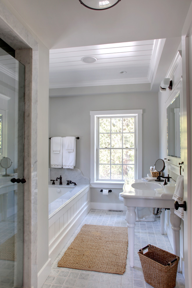 На фото: большая главная, серо-белая ванная комната в классическом стиле с консольной раковиной, полновстраиваемой ванной, душем в нише, серой плиткой, каменной плиткой и серыми стенами