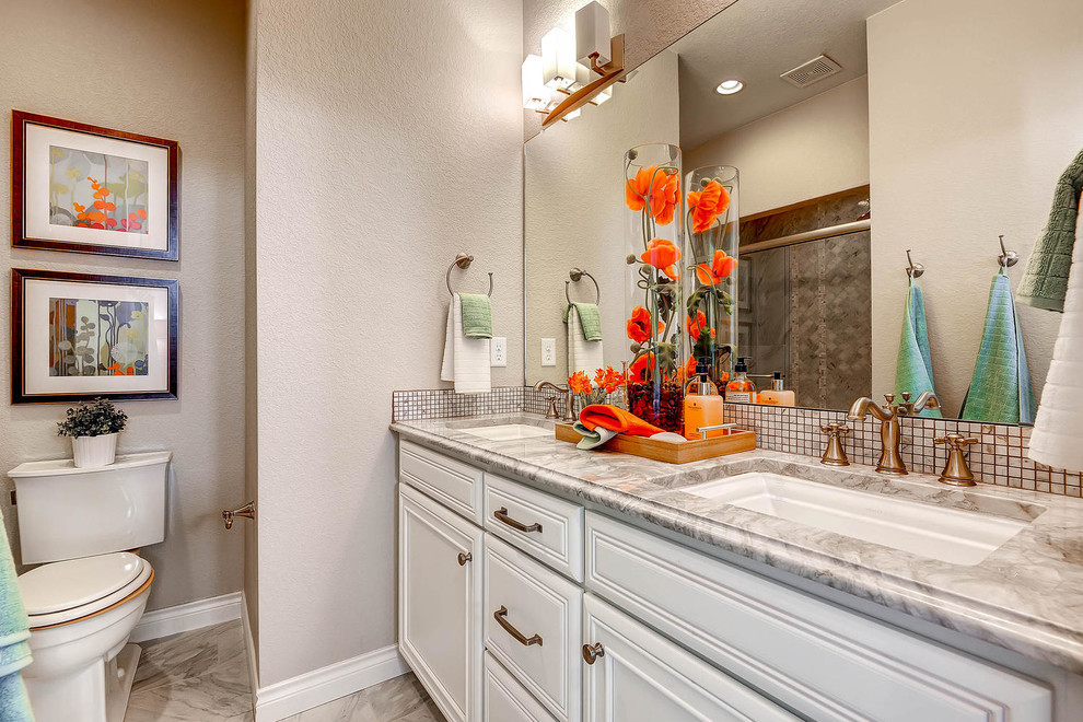 Photo of a classic bathroom in Denver with white cabinets, an alcove shower, a two-piece toilet, beige tiles, grey walls, a submerged sink and raised-panel cabinets.