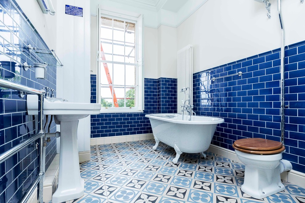Exemple d'une salle de bain victorienne de taille moyenne avec une baignoire sur pieds, un carrelage bleu, un carrelage métro, un mur marron, un sol bleu, WC à poser, un sol en carrelage de céramique et un plan vasque.