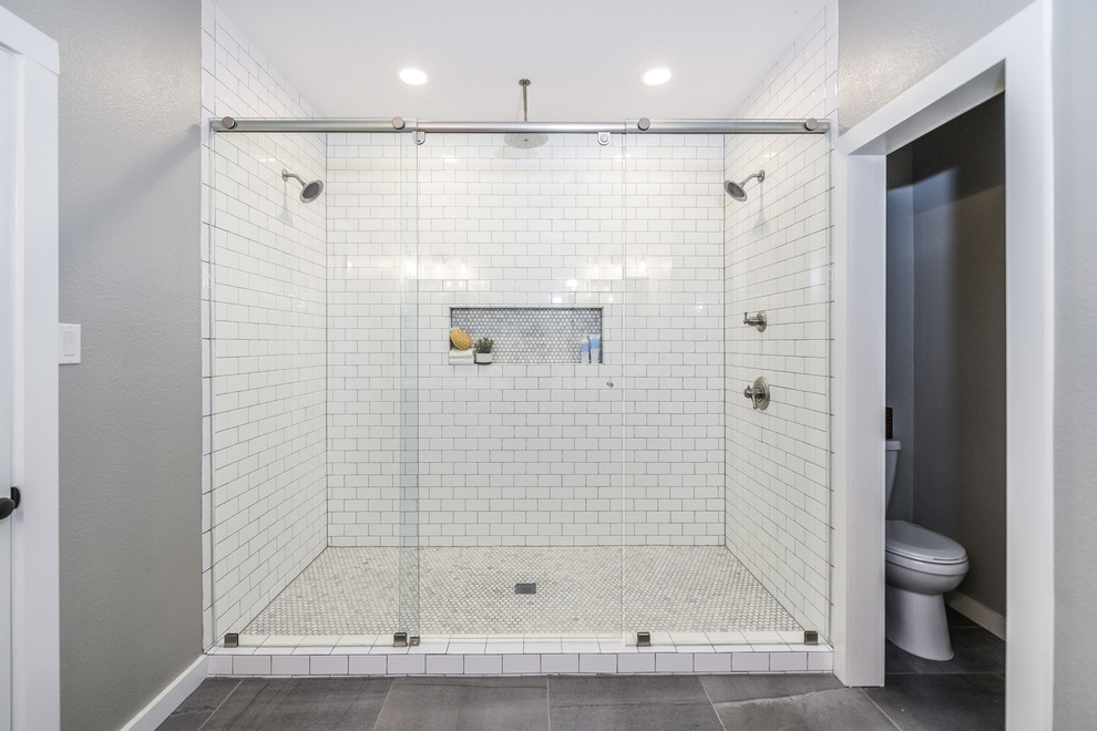 Пример оригинального дизайна: главная ванная комната в стиле кантри с фасадами в стиле шейкер, серыми фасадами, двойным душем, белой плиткой, керамической плиткой, серыми стенами, полом из керамической плитки, врезной раковиной, столешницей из гранита, серым полом и душем с раздвижными дверями
