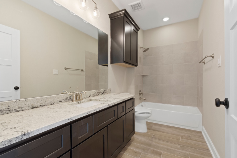 Inredning av ett badrum, med ett platsbyggt badkar, en öppen dusch, klinkergolv i porslin och granitbänkskiva