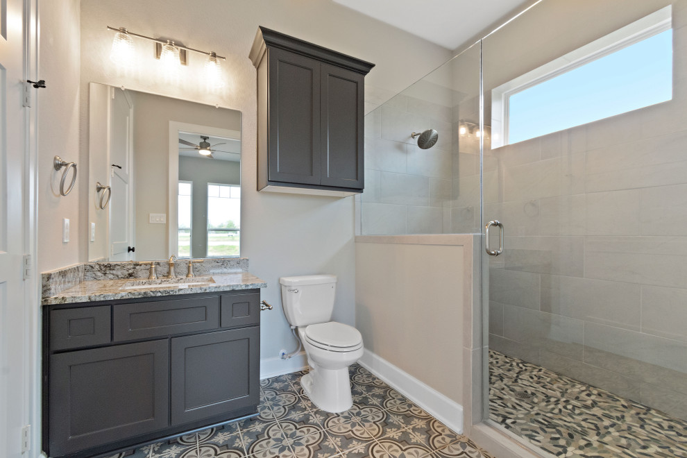 ヒューストンにあるおしゃれな浴室 (ドロップイン型浴槽、オープン型シャワー、木目調タイル、磁器タイルの床、御影石の洗面台) の写真