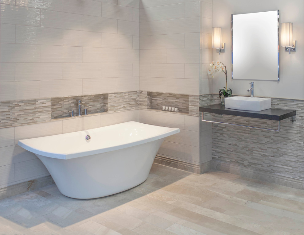 Imagen de cuarto de baño actual con bañera exenta, baldosas y/o azulejos de cerámica y suelo de mármol