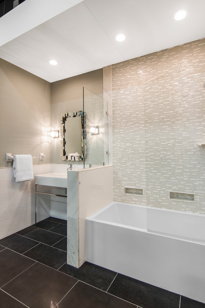 На фото: ванная комната в современном стиле с белыми фасадами, ванной в нише, душем над ванной, белой плиткой, плиткой из листового стекла, бежевыми стенами, полом из керамической плитки и раковиной с несколькими смесителями с