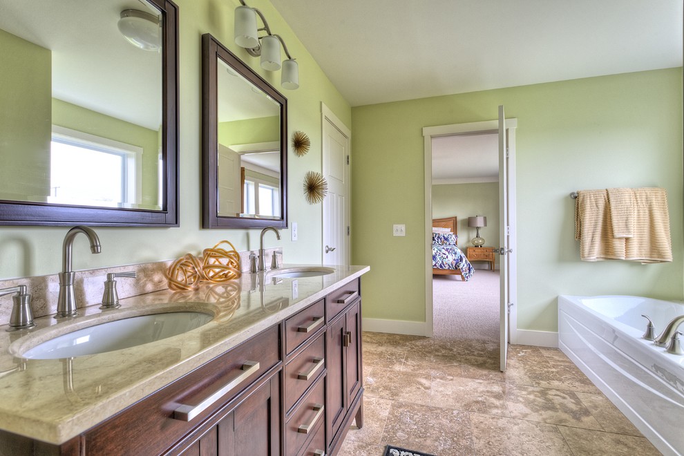 Inredning av ett amerikanskt en-suite badrum, med ett undermonterad handfat, möbel-liknande, skåp i mellenmörkt trä, granitbänkskiva, ett badkar i en alkov, en dusch i en alkov, en toalettstol med separat cisternkåpa, gröna väggar och klinkergolv i porslin