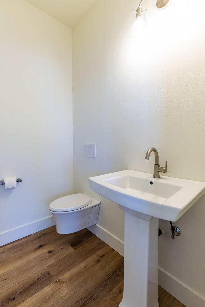 Réalisation d'un petit WC suspendu minimaliste avec un mur blanc, parquet clair, un lavabo de ferme, un plan de toilette en quartz modifié et un sol gris.