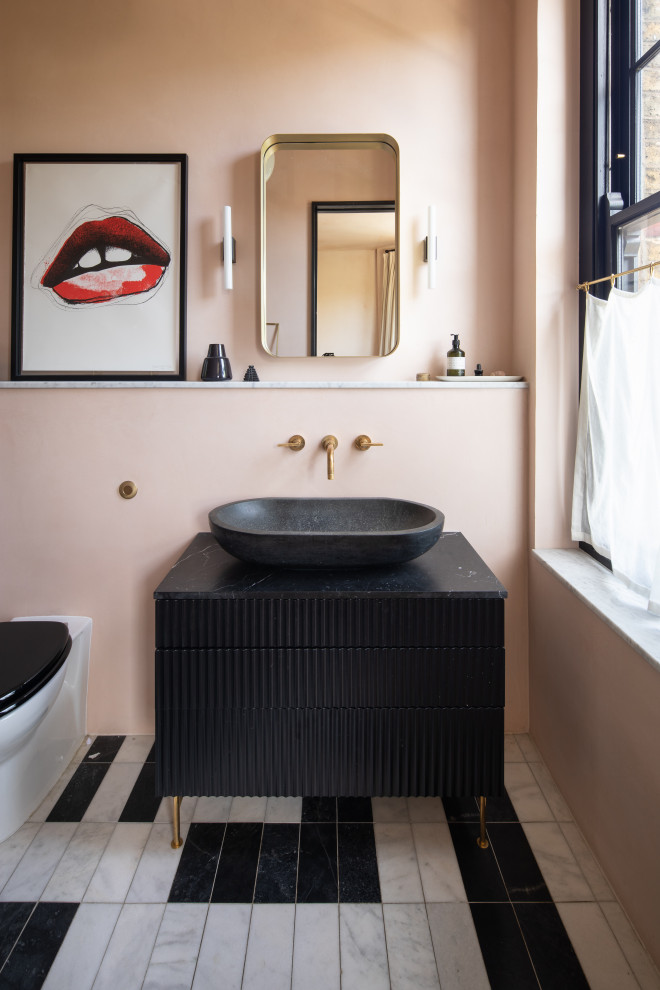 ロンドンにあるエクレクティックスタイルのおしゃれな浴室 (フラットパネル扉のキャビネット、黒いキャビネット、ピンクの壁、ベッセル式洗面器、マルチカラーの床、黒い洗面カウンター、洗面台1つ、独立型洗面台) の写真