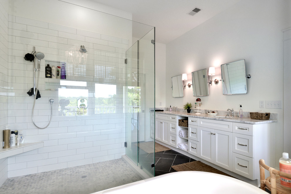 Example of a mid-sized classic master white tile and subway tile porcelain tile and black floor bathroom design in Charleston with shaker cabinets, white cabinets, white walls, an undermount sink, marble countertops, a hinged shower door and gray countertops