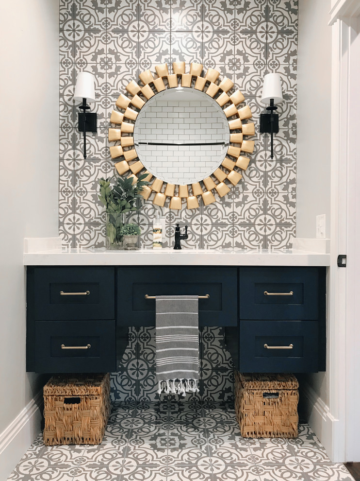 Inspiration pour une salle de bain traditionnelle de taille moyenne avec un placard à porte shaker, des portes de placard bleues, un carrelage gris, un carrelage blanc, un mur gris, un sol multicolore et un plan de toilette blanc.
