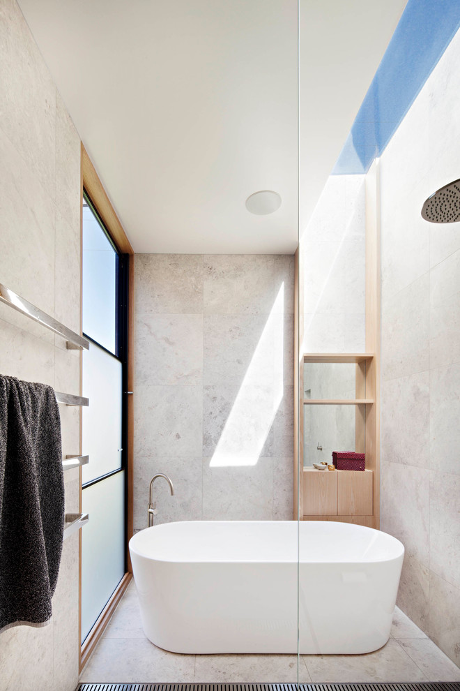 Diseño de cuarto de baño principal minimalista sin sin inodoro con armarios abiertos, puertas de armario de madera clara, bañera exenta, paredes grises, suelo gris y ducha abierta