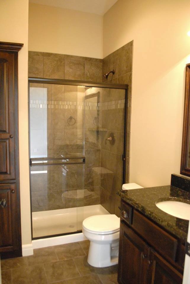 Corner shower - mid-sized mediterranean 3/4 beige tile and ceramic tile ceramic tile corner shower idea in Kansas City with an undermount sink, raised-panel cabinets, dark wood cabinets, a one-piece toilet and beige walls