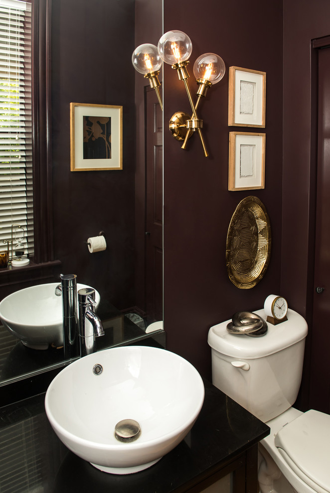Diseño de cuarto de baño clásico renovado pequeño con sanitario de una pieza, paredes púrpuras, suelo de corcho, aseo y ducha, lavabo sobreencimera, encimera de granito, suelo marrón y encimeras negras