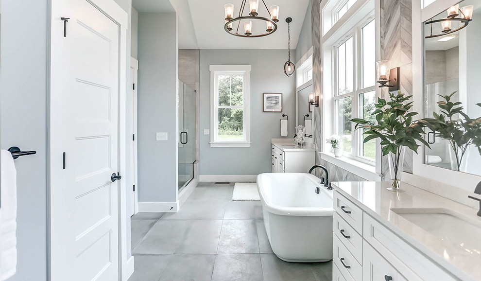 Exempel på ett stort lantligt beige beige en-suite badrum, med vita skåp, ett fristående badkar, en dusch i en alkov, en toalettstol med hel cisternkåpa, grå kakel, blå väggar, klinkergolv i keramik, ett undermonterad handfat, bänkskiva i kvarts, grått golv och dusch med gångjärnsdörr