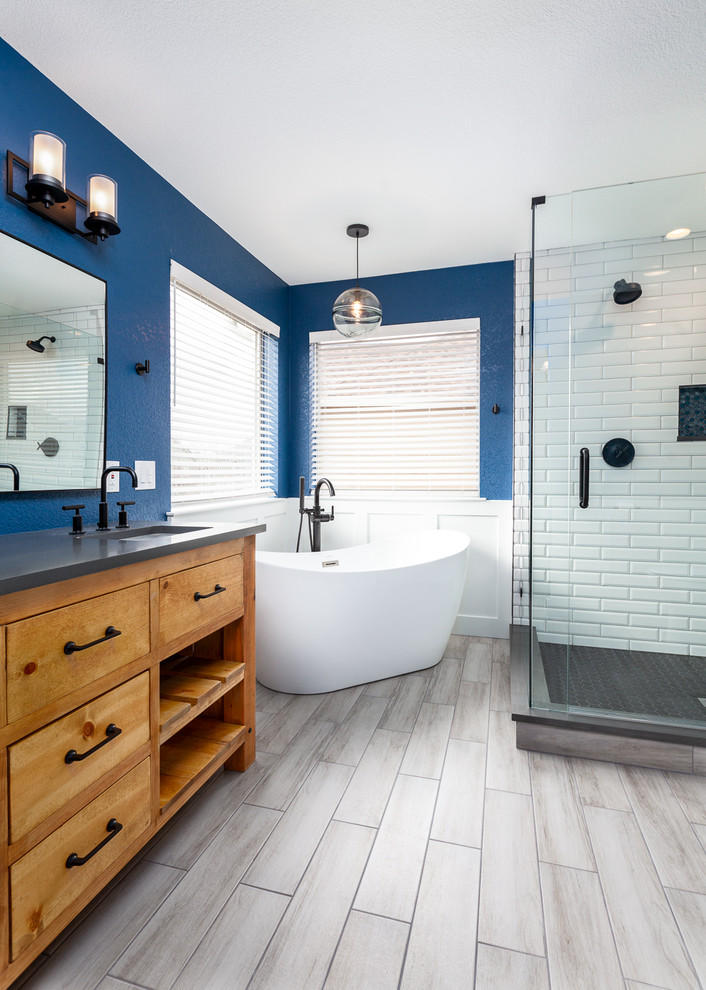 デンバーにある高級な中くらいなおしゃれなマスターバスルーム (置き型浴槽、コーナー設置型シャワー、青い壁、グレーの床、開き戸のシャワー) の写真