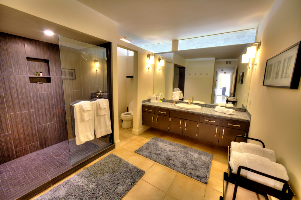 Immagine di una grande stanza da bagno padronale moderna con lavabo a consolle, top in vetro, vasca da incasso, doccia aperta, WC monopezzo, piastrelle marroni, piastrelle di vetro, pareti bianche e pavimento con piastrelle in ceramica