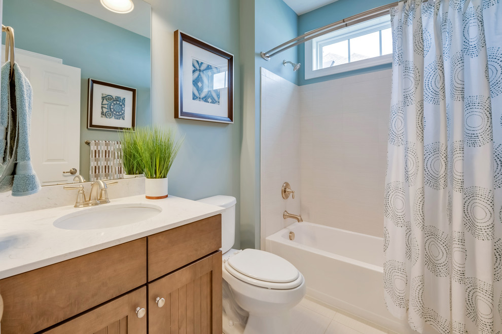 Bathroom - mid-sized shabby-chic style white tile and porcelain tile porcelain tile and beige floor bathroom idea in Other with beaded inset cabinets, brown cabinets, a two-piece toilet, blue walls, a drop-in sink and solid surface countertops