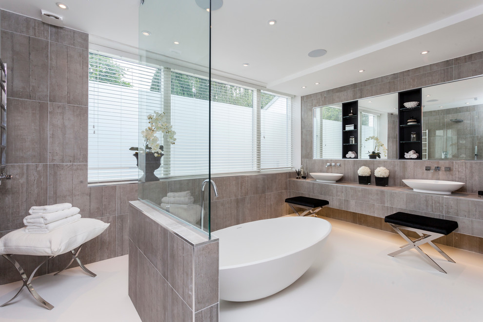 Идея дизайна: главная ванная комната в современном стиле с настольной раковиной, отдельно стоящей ванной, серой плиткой и окном