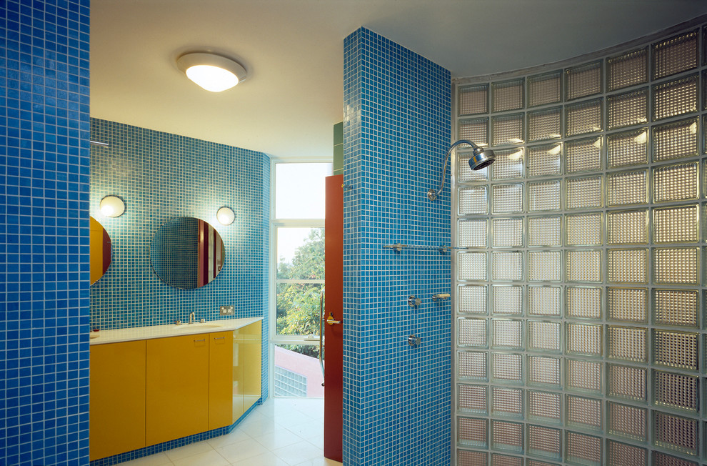 Bild på ett stort funkis en-suite badrum, med släta luckor, gula skåp, en öppen dusch, blå kakel, mosaik, blå väggar och med dusch som är öppen